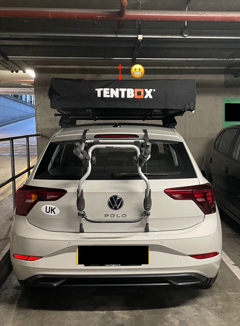 car in an underground parking with a tentbox almost touching the ceiling