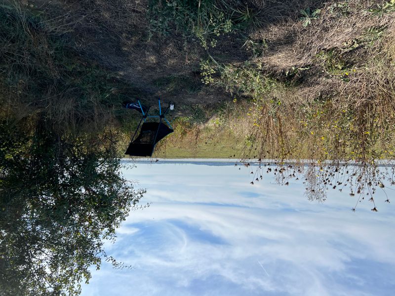 a helinox chair under a tree overlooking the Thames